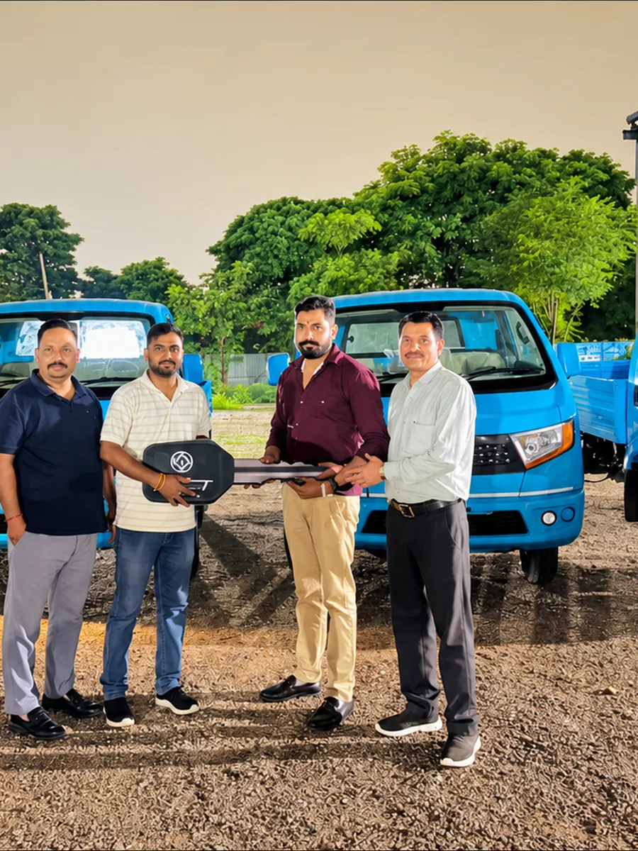 Key handover in front of a row of new Ashok Leyland light commercial vehicles